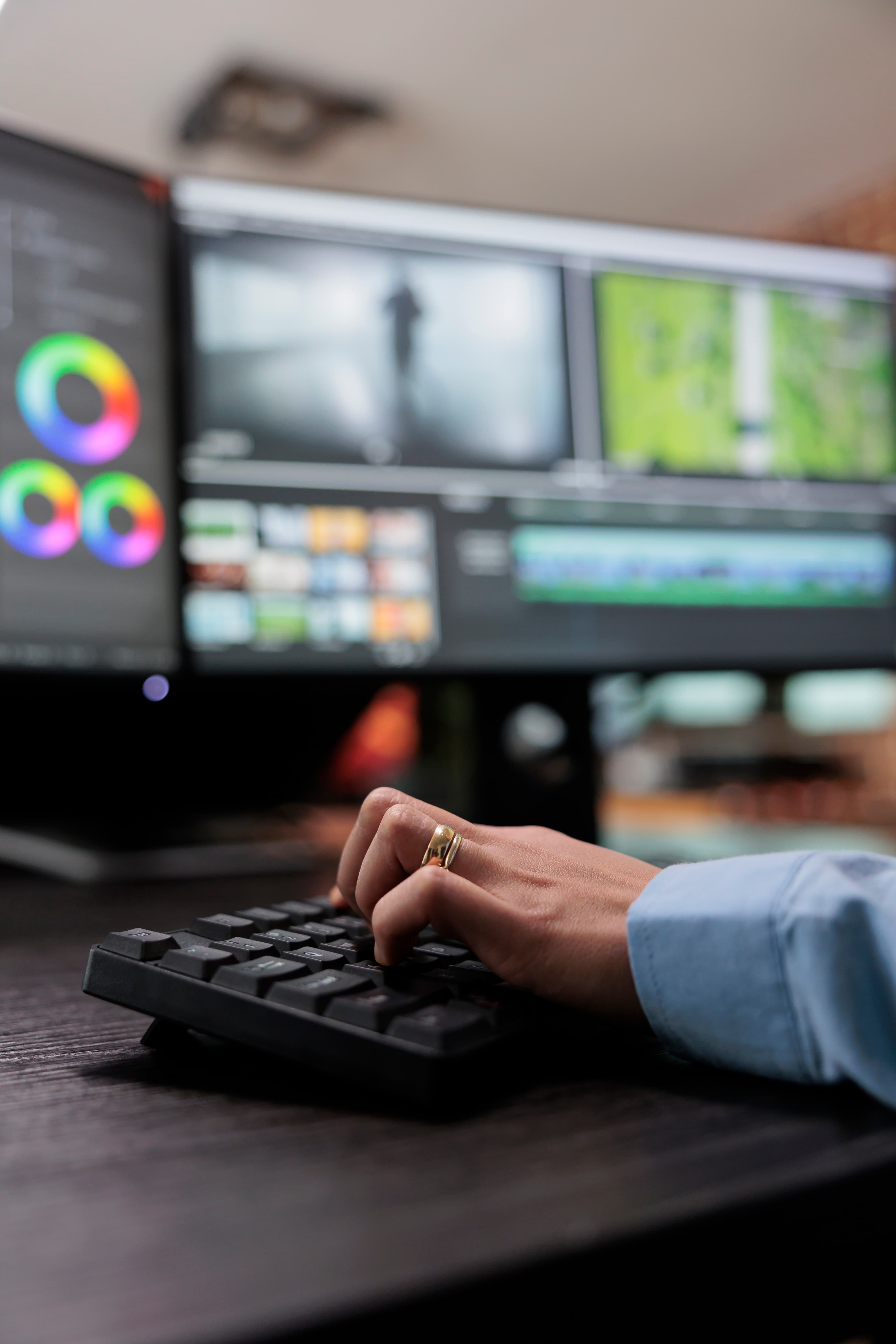 Color suite with footage on the monitors and a hand on the keyboard